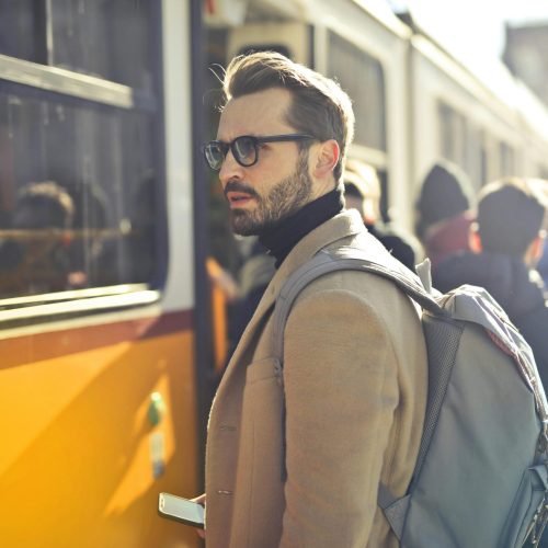 pexels-photo-837358-837358 A stylish man with a backpack boards a tram in bustling Budapest, Hungary, during the day.